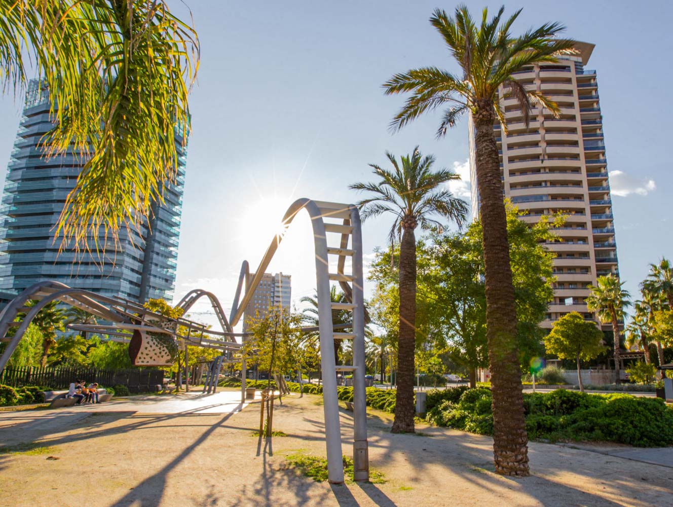 Palm trees and high-rise towers in Barcelona's Diagonal Mar park on a sunny day