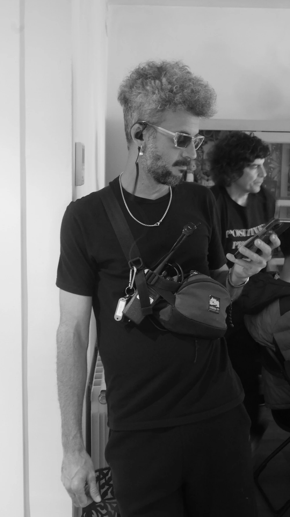 Black-and-white portrait of a Glassy Films crew member with a radio earpiece on set
