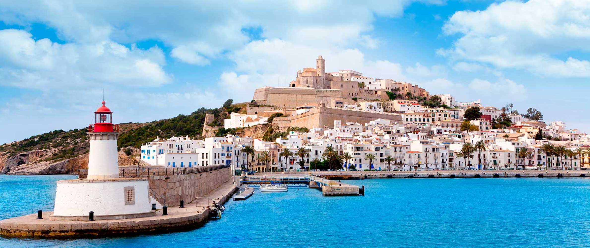 Ibiza old town and harbour lighthouse over turquoise water