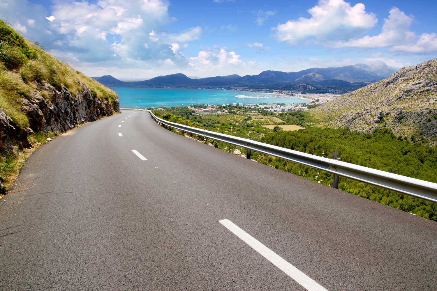Coastal mountain road overlooking a turquoise bay