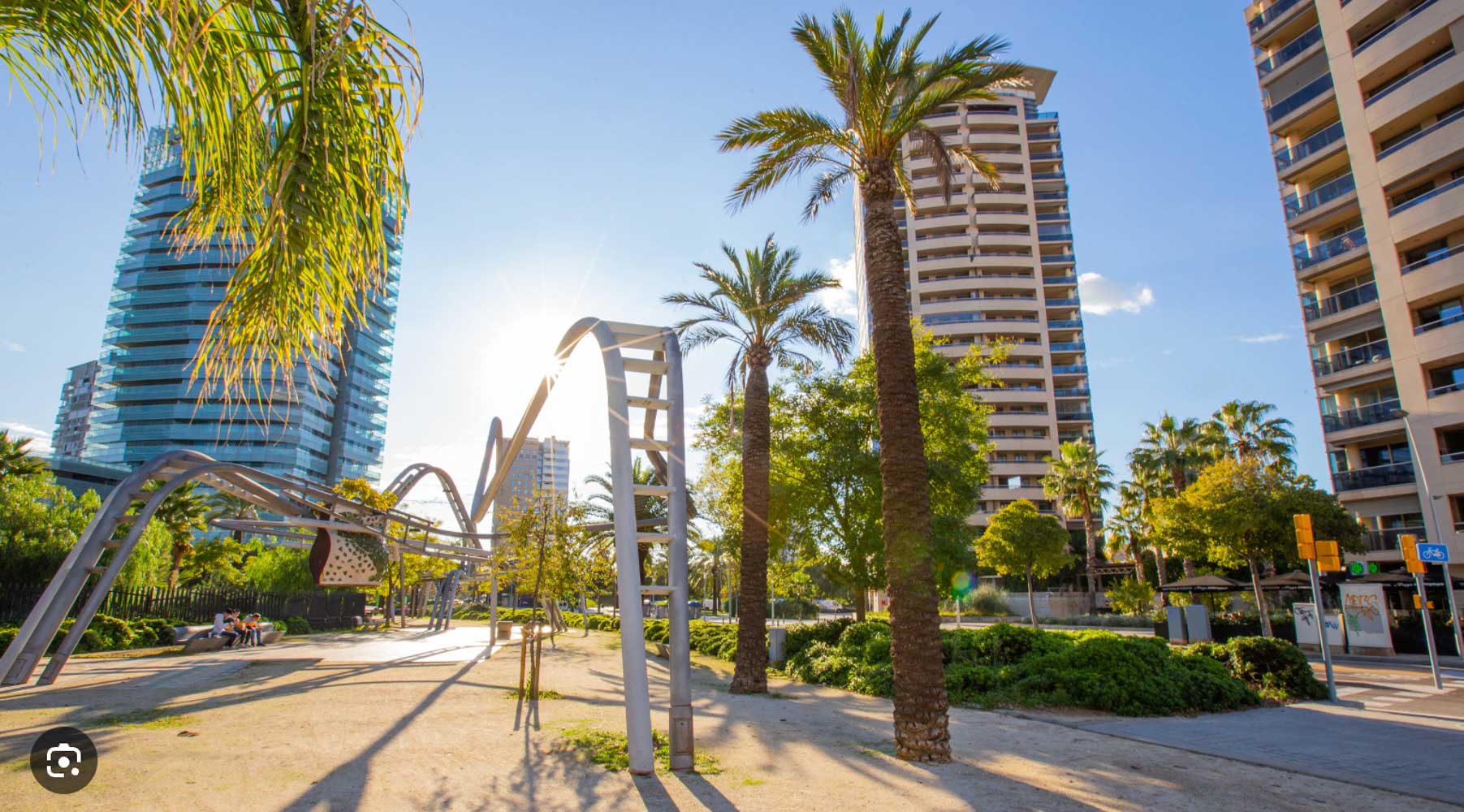 Palm trees and modern towers in Barcelona's Diagonal Mar park